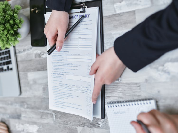  A cropped photo of a person pointing to a life insurance policy document