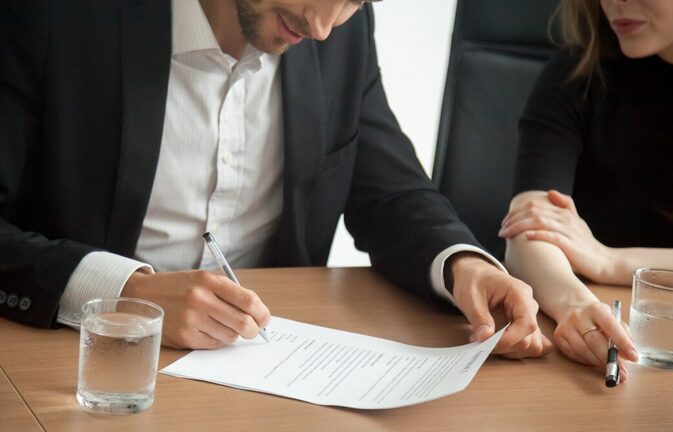 A picture of a person signing a document