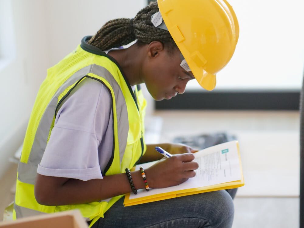 a contractor with a safety helmet holding a pen.