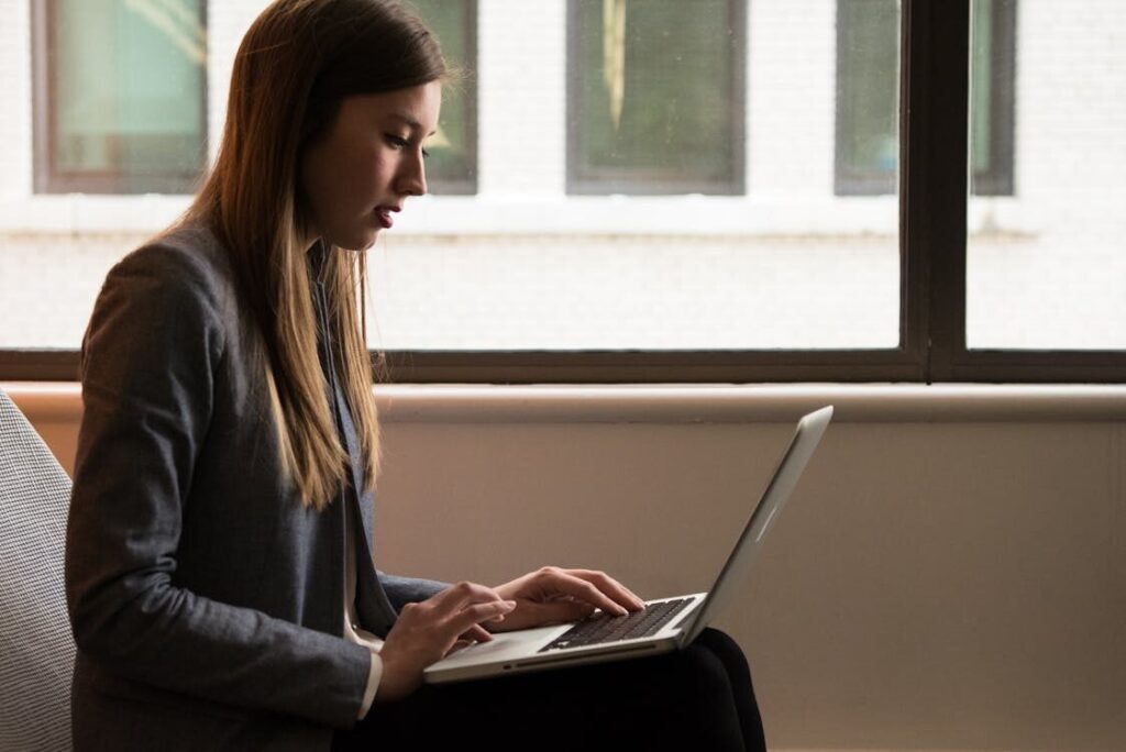 a woman with blonde hair typing on her computer.
